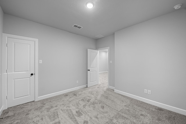 carpeted empty room with visible vents and baseboards