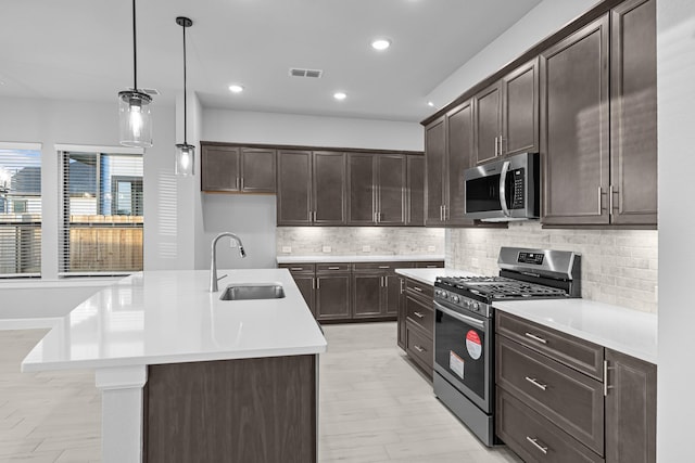 kitchen with a sink, light countertops, dark brown cabinets, and stainless steel appliances