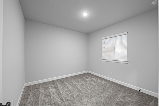 unfurnished room with carpet flooring and baseboards