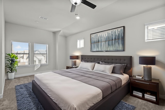 carpeted bedroom with visible vents, baseboards, and ceiling fan