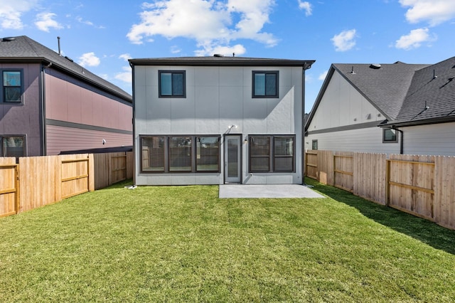 rear view of house with a patio, a lawn, and a fenced backyard