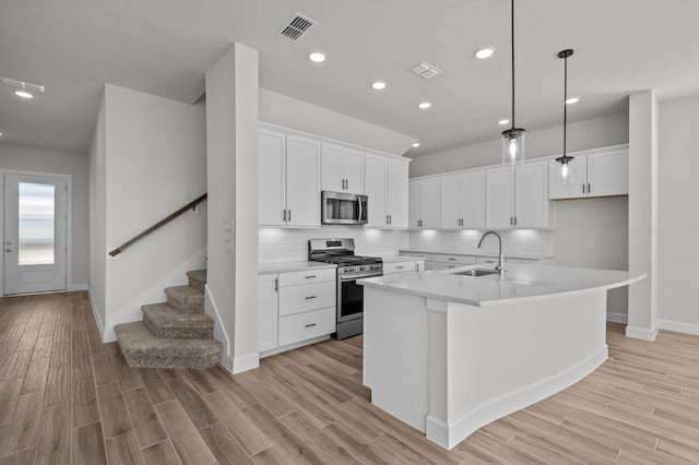 kitchen with visible vents, appliances with stainless steel finishes, light wood-style floors, and a sink