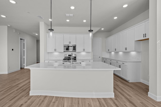 kitchen with visible vents, appliances with stainless steel finishes, light wood-style flooring, and light countertops