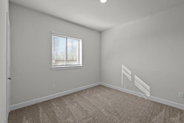 unfurnished room with baseboards and carpet floors