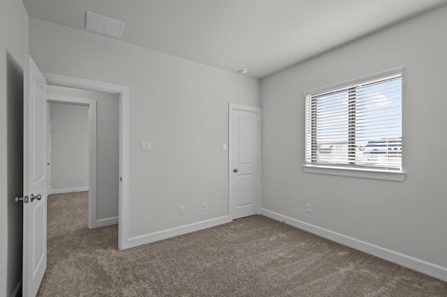 unfurnished bedroom with visible vents, baseboards, and carpet