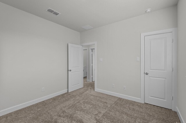 unfurnished bedroom featuring visible vents, carpet flooring, and baseboards