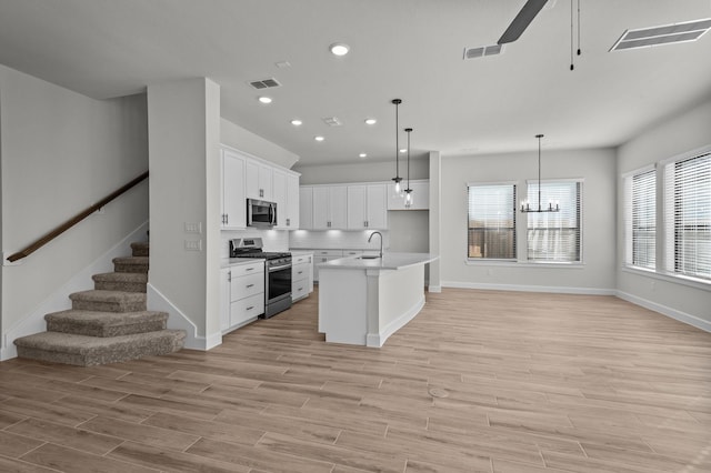 kitchen with light wood-style flooring, visible vents, appliances with stainless steel finishes, and a sink