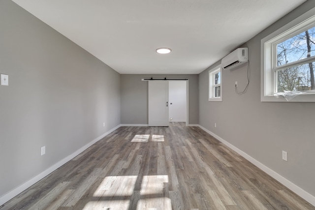 71 Deer Run Cir, Coldspring, TX 77331 - spare room with a barn door, a wall unit AC, wood finished floors, and baseboards