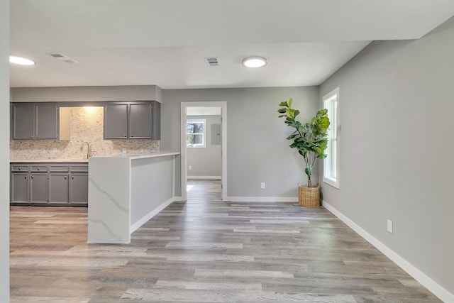 71 Deer Run Cir, Coldspring, TX 77331 - kitchen featuring gray cabinetry, light countertops, decorative backsplash, baseboards, and light wood-style floors