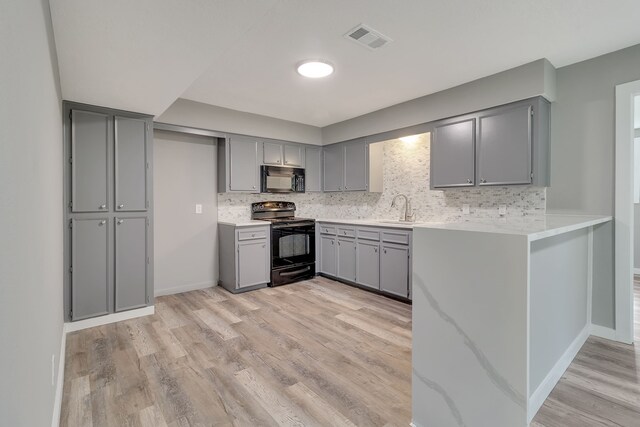 71 Deer Run Cir, Coldspring, TX 77331 - kitchen with black appliances, gray cabinets, a sink, and light wood-style flooring
