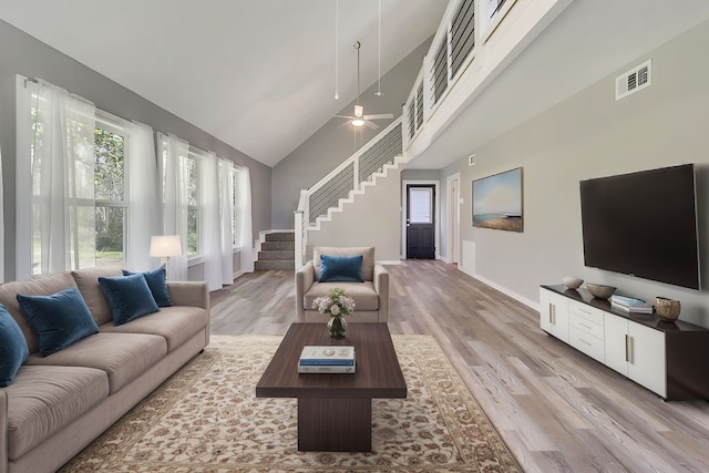 71 Deer Run Cir, Coldspring, TX 77331 - living area with stairway, light wood-style flooring, baseboards, high vaulted ceiling, and ceiling fan