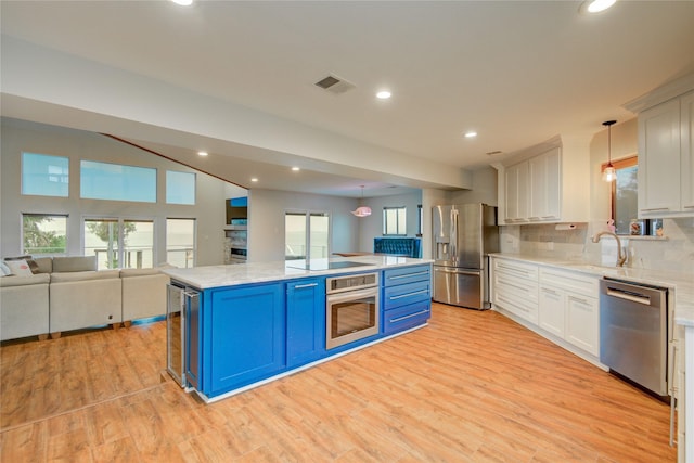 456 S Burnett Dr, Baytown, TX 77520 - kitchen featuring a sink, light wood finished floors, appliances with stainless steel finishes, visible vents, and blue cabinetry
