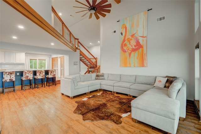 456 S Burnett Dr, Baytown, TX 77520 - living room with visible vents, a high ceiling, wood finished floors, and stairway