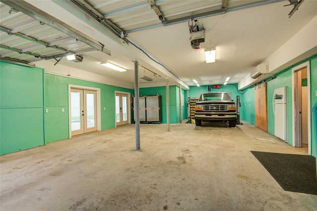 456 S Burnett Dr, Baytown, TX 77520 - garage featuring french doors, a wall unit AC, freestanding refrigerator, and a garage door opener