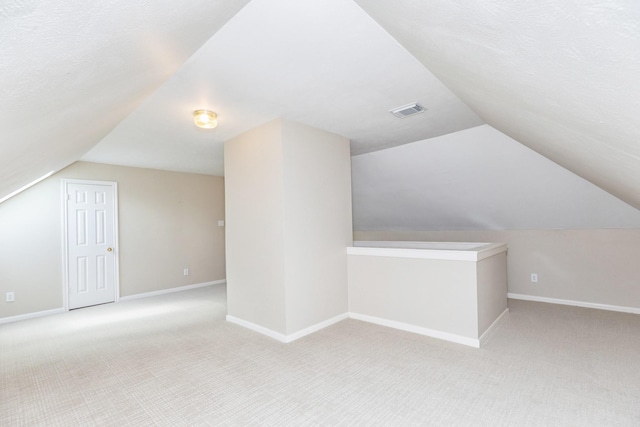 bonus room featuring visible vents, carpet flooring, baseboards, and vaulted ceiling