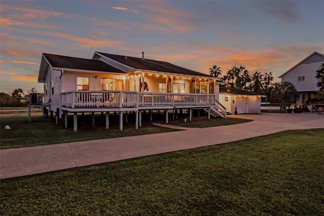 back of property with a garage, a lawn, central AC, and a deck