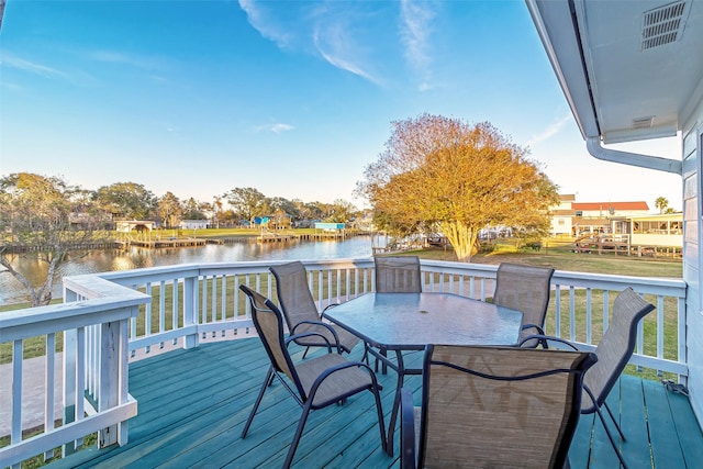 wooden terrace featuring a water view and outdoor dining space