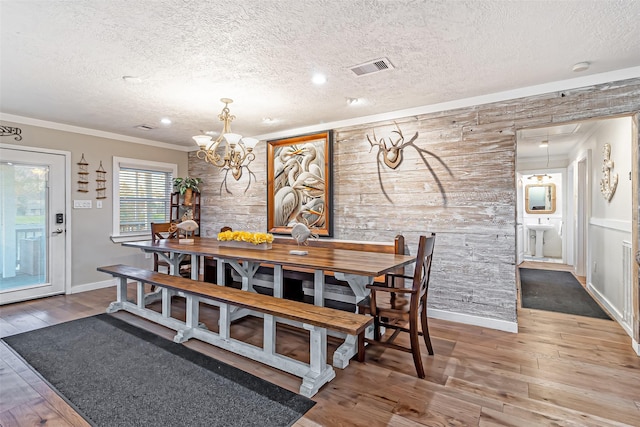 dining room featuring a notable chandelier, a textured ceiling, and hardwood / wood-style floors