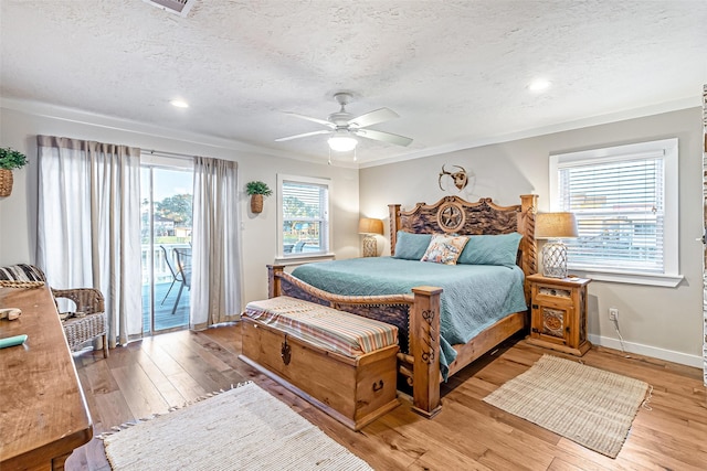 bedroom with access to exterior, baseboards, light wood-type flooring, and a textured ceiling