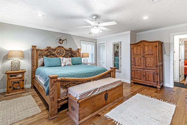 bedroom featuring crown molding, wood finished floors, baseboards, and a textured ceiling