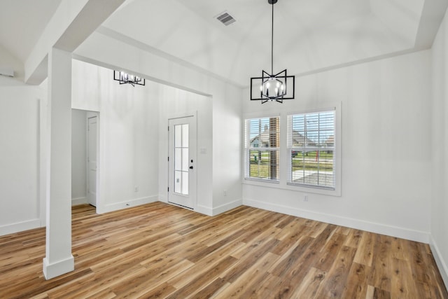 unfurnished dining area with visible vents, baseboards, an inviting chandelier, and light wood-style flooring