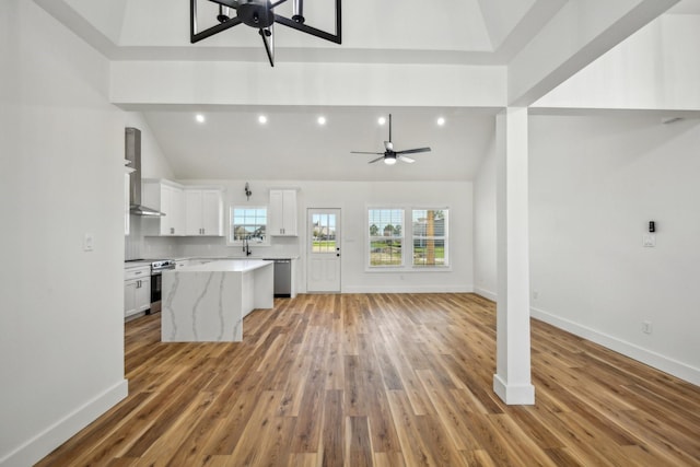 kitchen featuring a kitchen island, ceiling fan, appliances with stainless steel finishes, white cabinetry, and open floor plan
