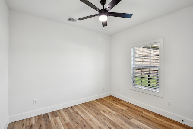 empty room with light wood-style floors, baseboards, and visible vents