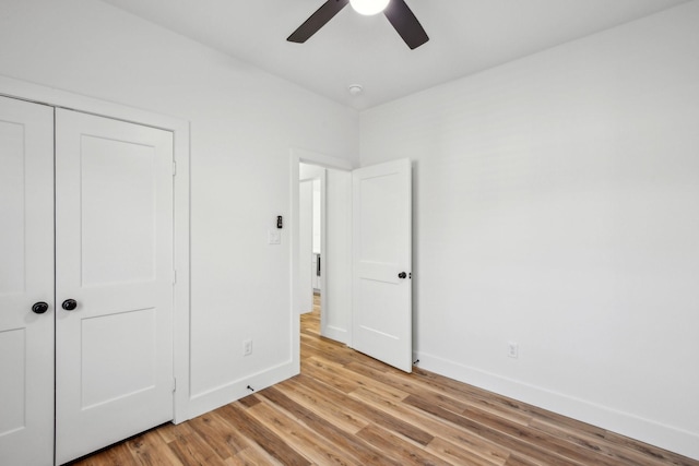unfurnished bedroom featuring light wood-style flooring, baseboards, a closet, and ceiling fan