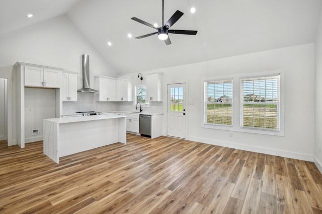 kitchen with a kitchen island, light countertops, dishwasher, wall chimney range hood, and light wood-type flooring