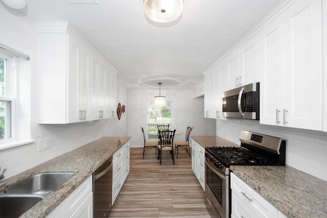 89 Bayou Ln, Kemah, TX 77565 - kitchen featuring appliances with stainless steel finishes, white cabinets, backsplash, and a textured ceiling