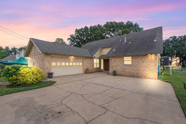 89 Bayou Ln, Kemah, TX 77565 - view of front of home featuring brick siding, a garage, concrete driveway, and roof with shingles