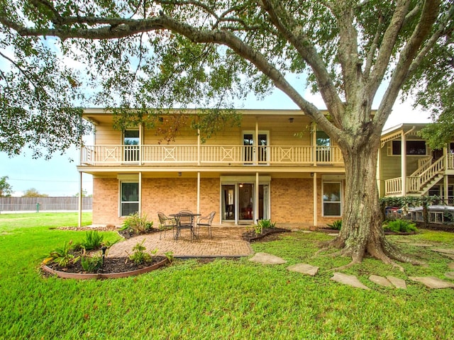 89 Bayou Ln, Kemah, TX 77565 - back of house with a balcony, a patio area, and brick siding