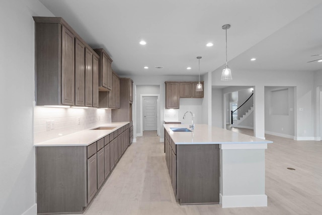 23507 Persimmon Creek Ln, Katy, TX 77493 - kitchen featuring an island with sink, light wood-style flooring, recessed lighting, tasteful backsplash, and black electric cooktop