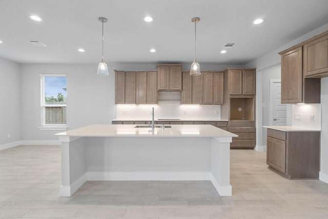 23507 Persimmon Creek Ln, Katy, TX 77493 - kitchen with backsplash, a center island with sink, light countertops, and recessed lighting
