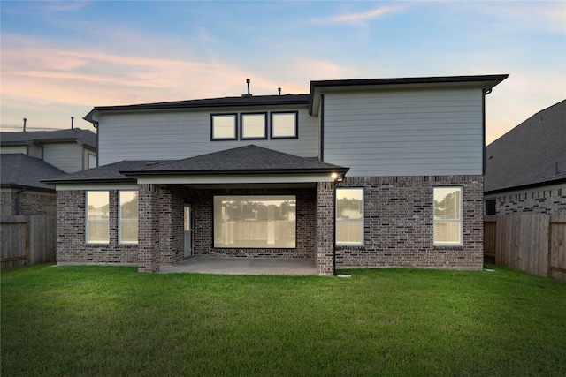 23507 Persimmon Creek Ln, Katy, TX 77493 - back of property at dusk featuring a patio, a fenced backyard, and brick siding