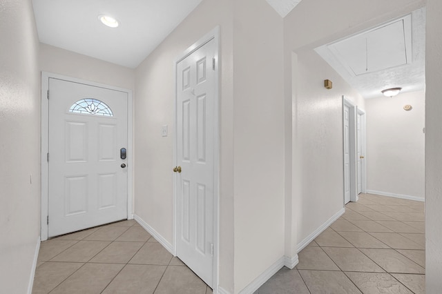 foyer entrance featuring light tile patterned flooring and baseboards