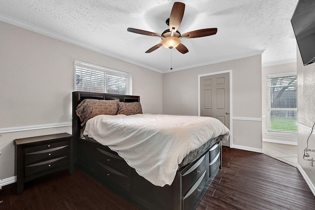 bedroom with dark wood-type flooring, multiple windows, crown molding, and a textured ceiling