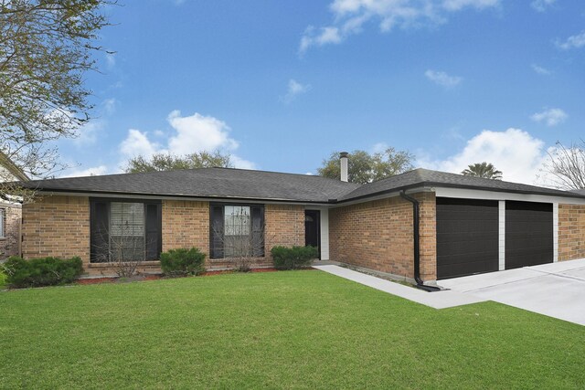 ranch-style home with driveway, a front lawn, a shingled roof, a garage, and brick siding