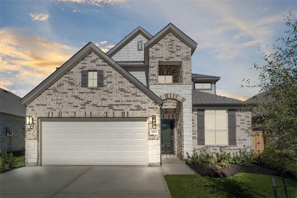 french country home featuring stone siding and driveway