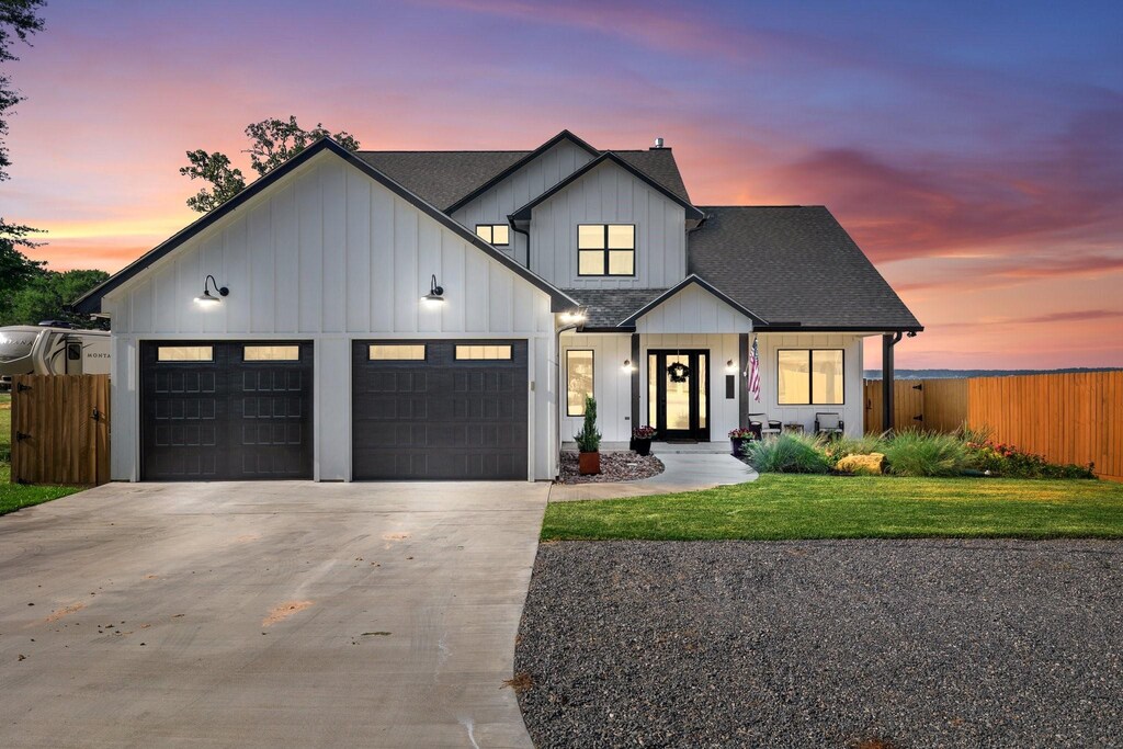 1152 Indian Hill Blvd, Livingston, TX 77351 - modern inspired farmhouse featuring a front lawn, fence, driveway, and a garage