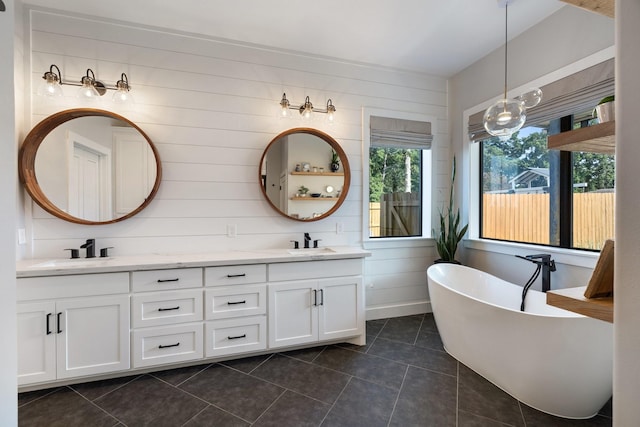 bathroom featuring a freestanding bath, a sink, and double vanity