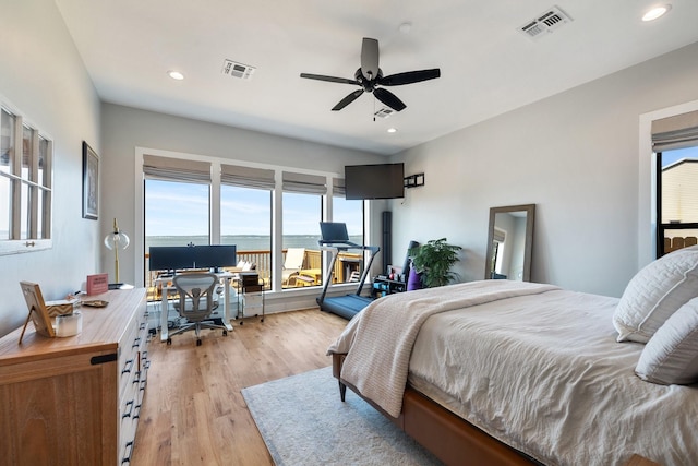 bedroom featuring light wood-style flooring, visible vents, and multiple windows
