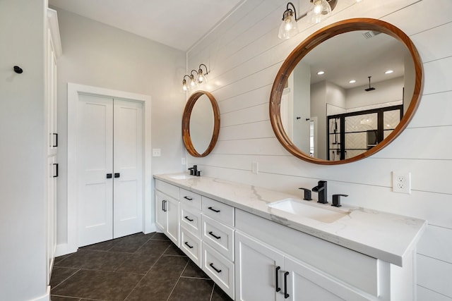 bathroom with tile patterned flooring, a sink, double vanity, and a stall shower