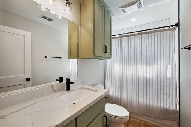 full bathroom with wood finished floors, visible vents, toilet, and vanity