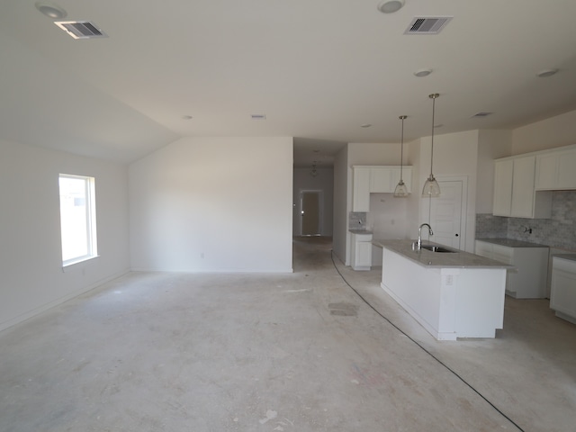 26239 Astral Way, La Marque, TX 77568 - kitchen featuring a center island with sink, tasteful backsplash, white cabinets, vaulted ceiling, and concrete floors