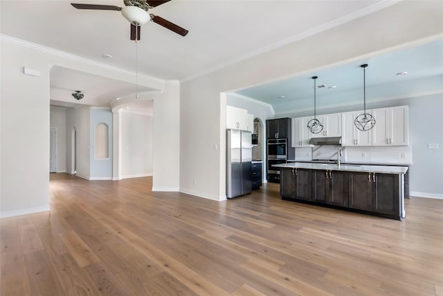 23509 Red Juniper Ln, New Caney, TX 77357 - kitchen featuring appliances with stainless steel finishes, open floor plan, a ceiling fan, white cabinets, and ornamental molding