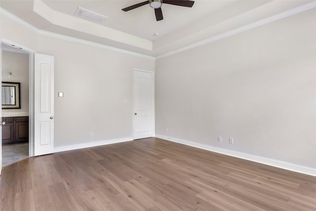 23509 Red Juniper Ln, New Caney, TX 77357 - empty room with a tray ceiling, ceiling fan, wood finished floors, baseboards, and crown molding