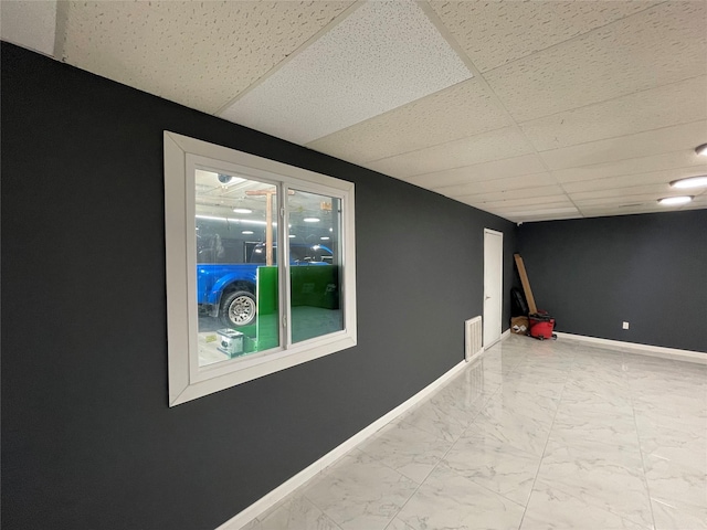 105 S 2nd St, Richmond, TX 77469 - finished below grade area with a paneled ceiling, baseboards, marble finish floor, and visible vents