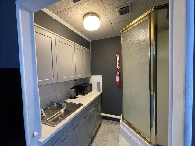 105 S 2nd St, Richmond, TX 77469 - interior space featuring visible vents, marble finish floor, a sink, backsplash, and black microwave