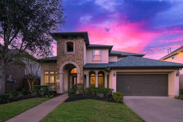 view of front of home with stucco siding, stone siding, a garage, and concrete driveway